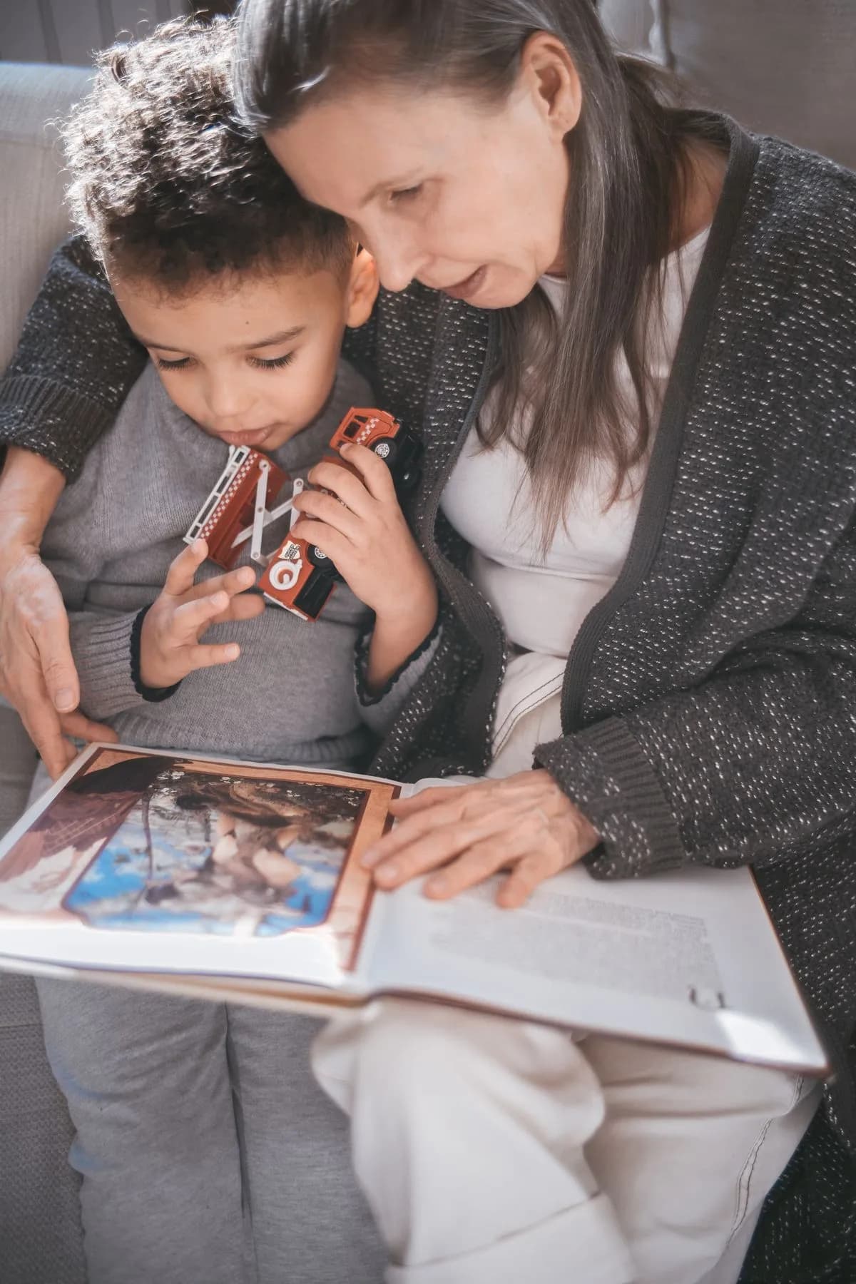 A parent and child looking at a photo album together.