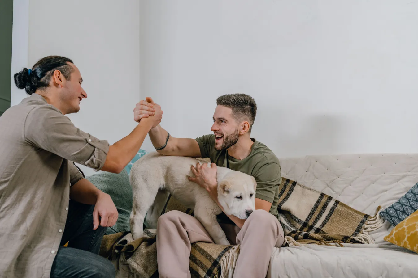 Two adults at home together on a sofa with their dog.